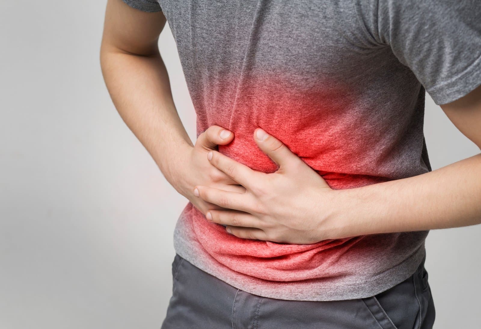 A man's torso seen from the front, both hands pressed flat to the upper abdomen. The abdominal cavity behind his hands is lit in red, spreading across the whole width of the belly rather than sitting at one point.